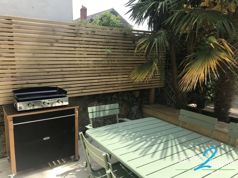 Clôture en bois avec barbecue et palmier - Paysagiste Nantes des Deux Rivières