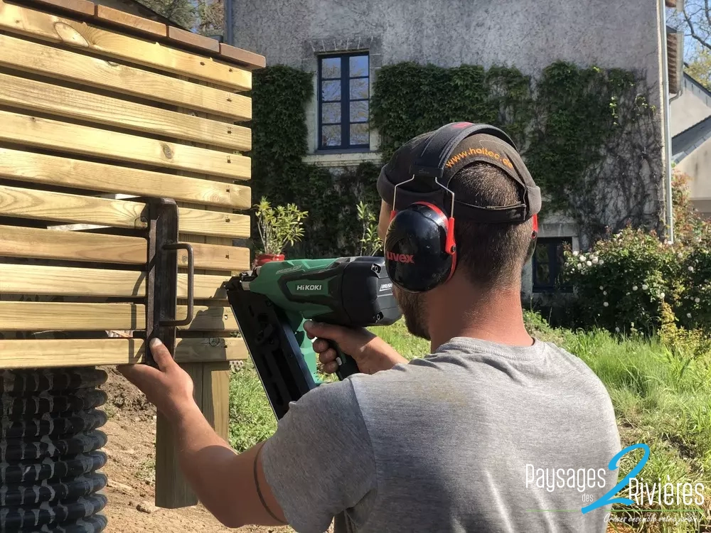 Personne de dos qui travaille le bois - Paysagiste Nantes des Deux Rivières